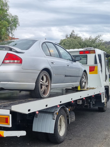 Big Boy's Tow truck towing a silver scrap car