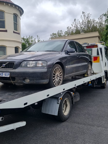 Big Boy's Tow truck towing a black sedan from a street