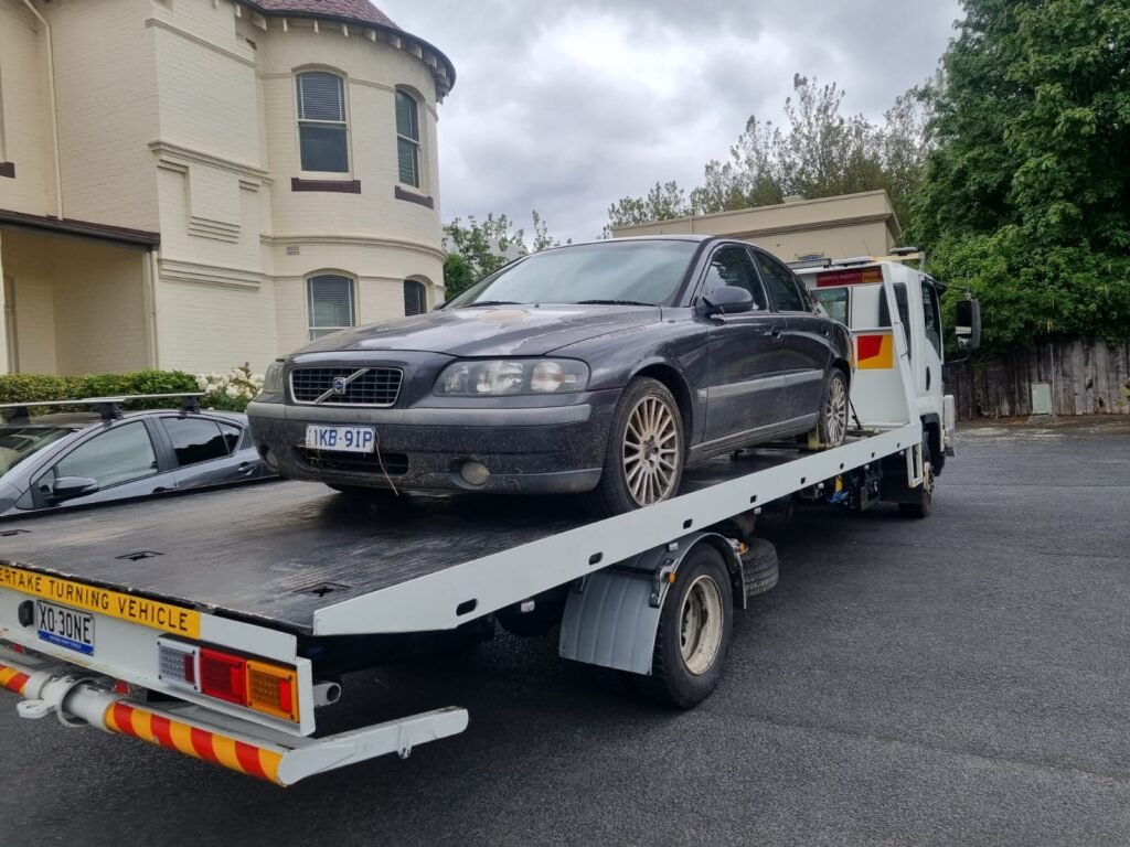 Long distance towing truck on a Tasmanian highway moving a car safely.