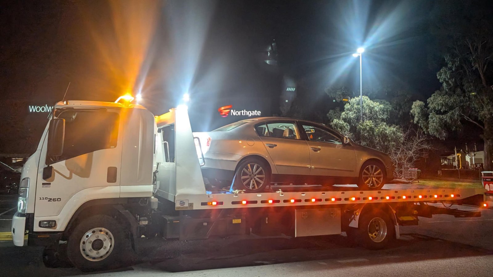 Big Boy Towing Truck towing a car at night