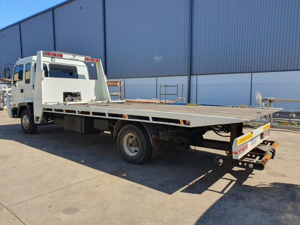 Tilt tray towing Hobart truck loading a luxury car safely.