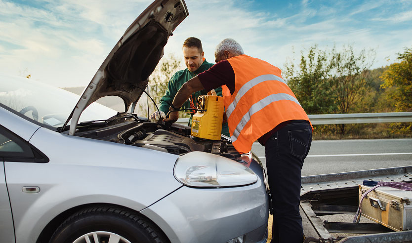 Roadside assistance Hobart technician jump starting a car battery.